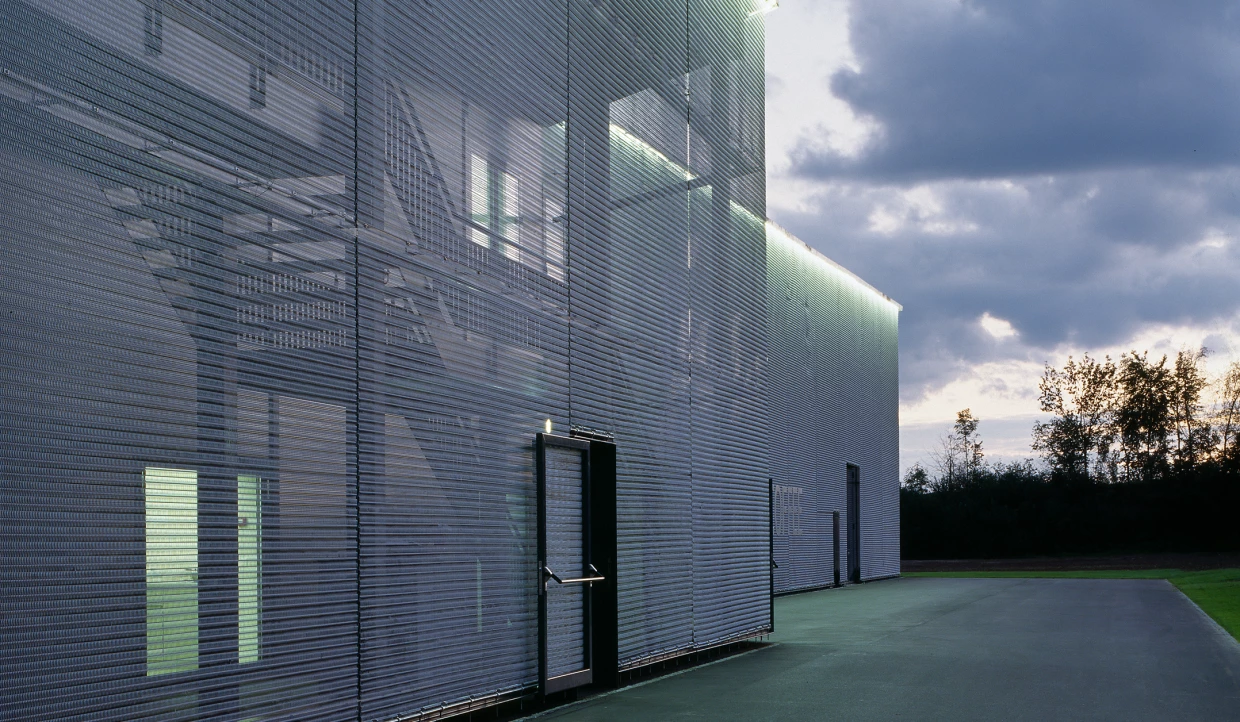 Side view of a building with metal cladding under cloudy sky