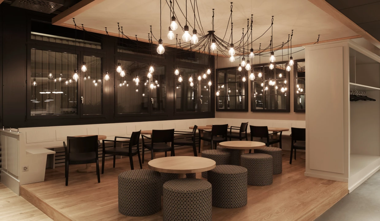 Cozy corner in a restaurant with round tables and string lights.