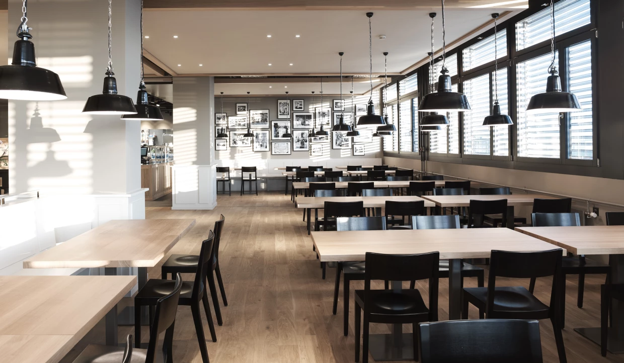 Bright dining room with black chairs and wooden tables.