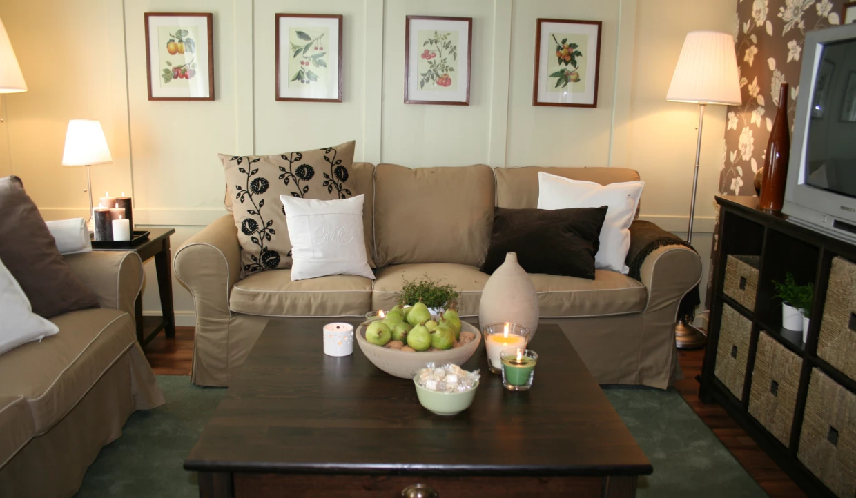 Wohnzimmer mit Sofa, Gemälden und Tischdeko