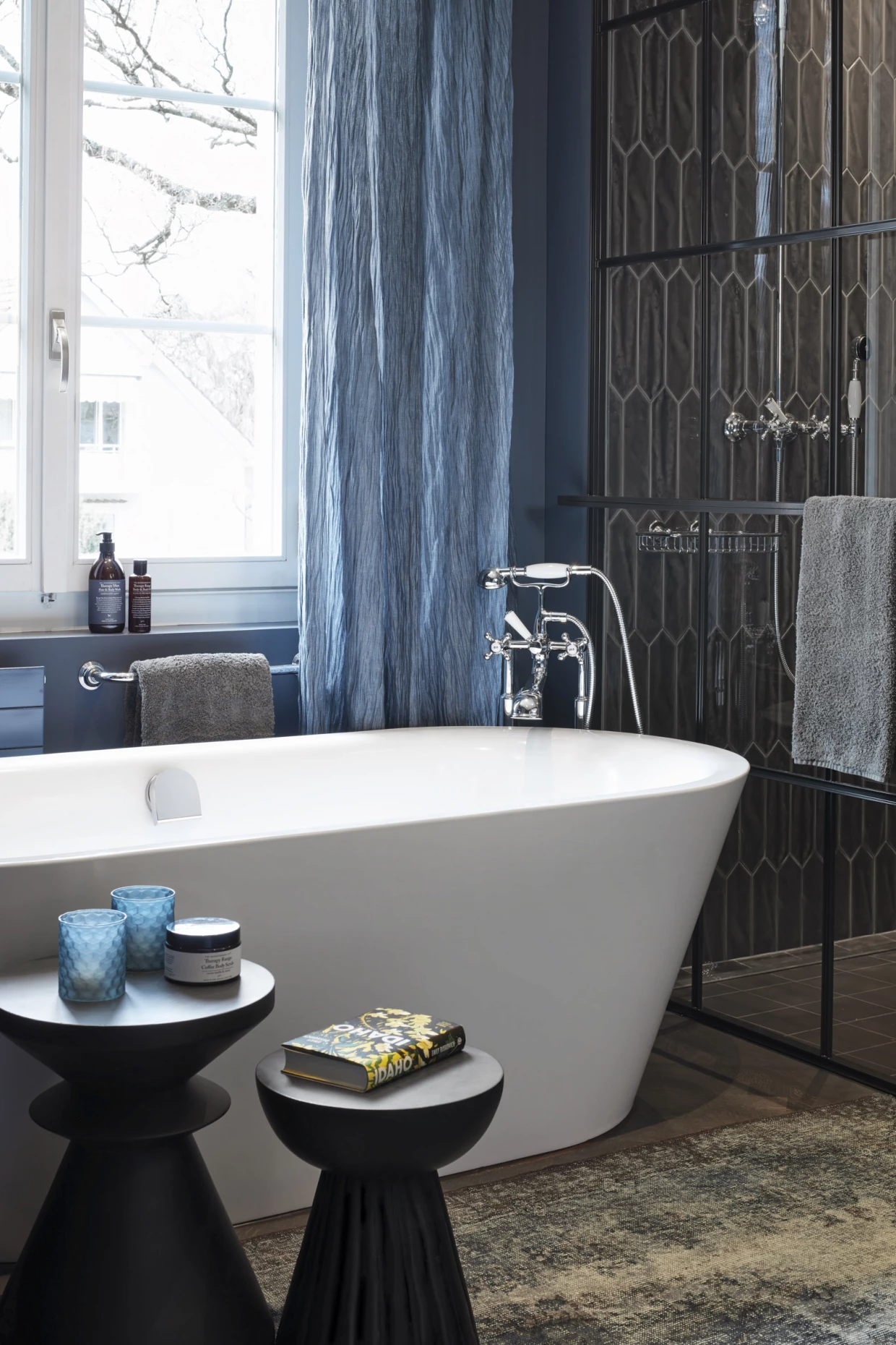 Badezimmer mit freistehender Badewanne und blauen Vorhängen