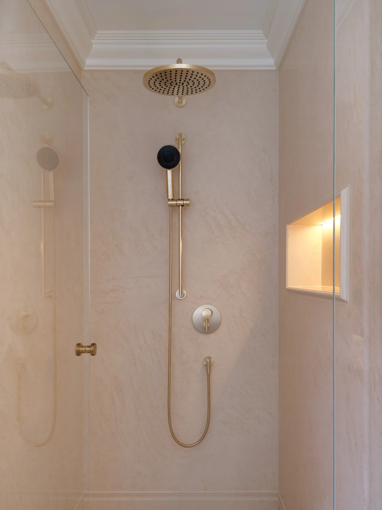 Dusche mit goldenen Armaturen und beigem Marmor