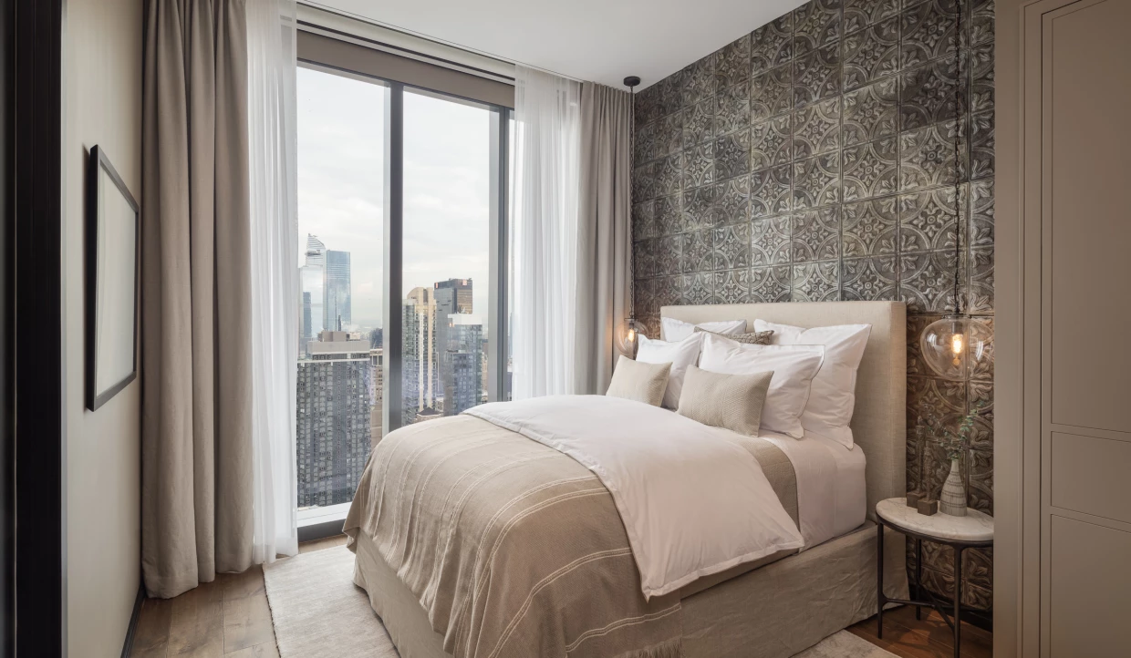 Gemütliches Schlafzimmer mit Mustertapete und Stadtblick