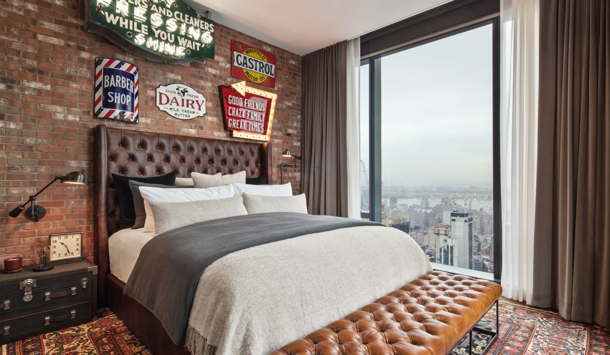 Schlafzimmer mit Backsteinwand und Vintage-Schildern
