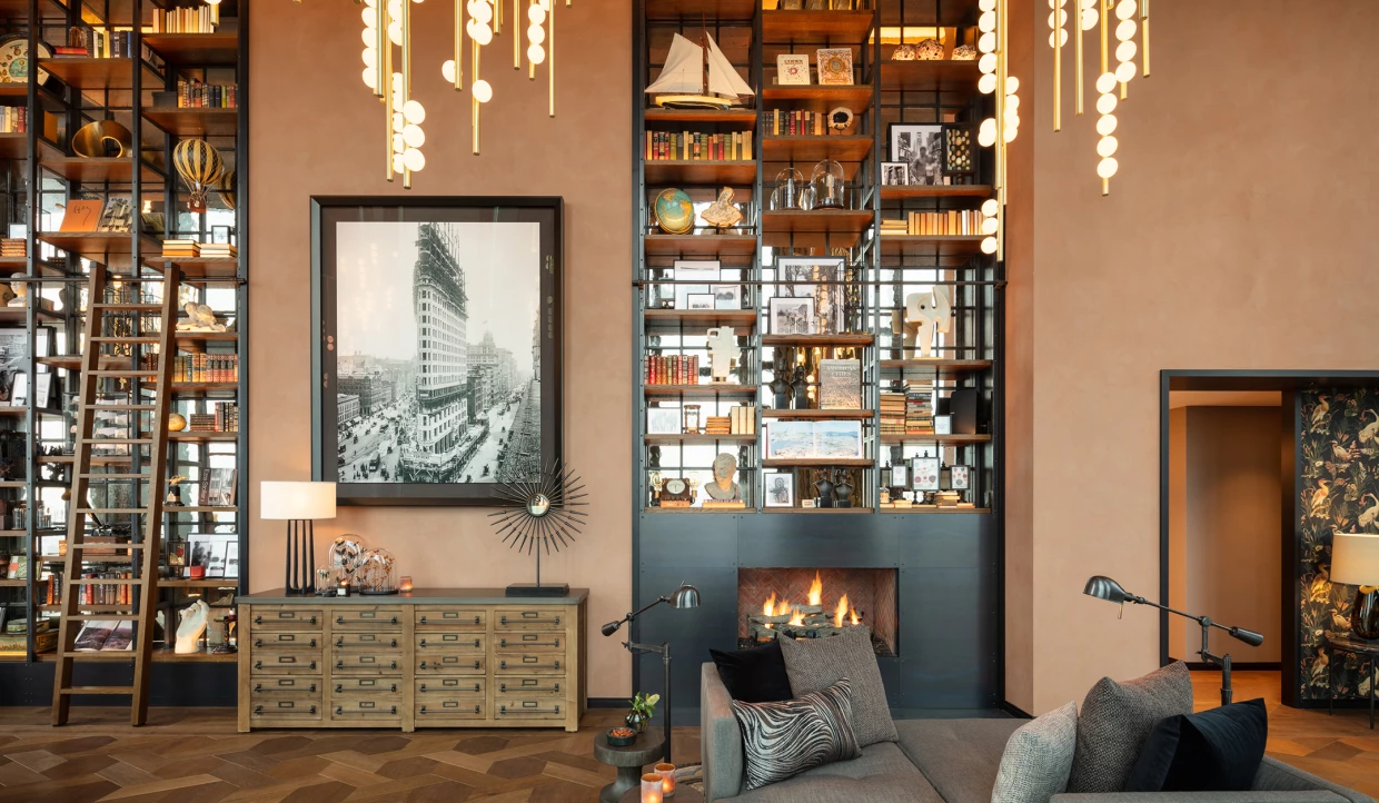 Wohnzimmer mit großer Bücherwand und Kamin