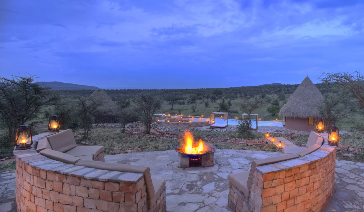 Fire pit surrounded by benches in the evening.