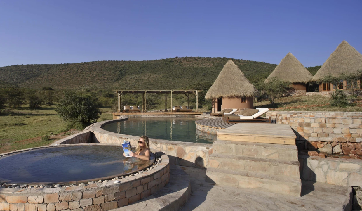 Person in a round pool overlooking huts.