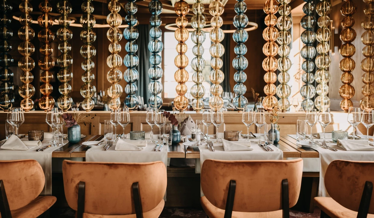 Restaurant interior with colorful glass chains and set table