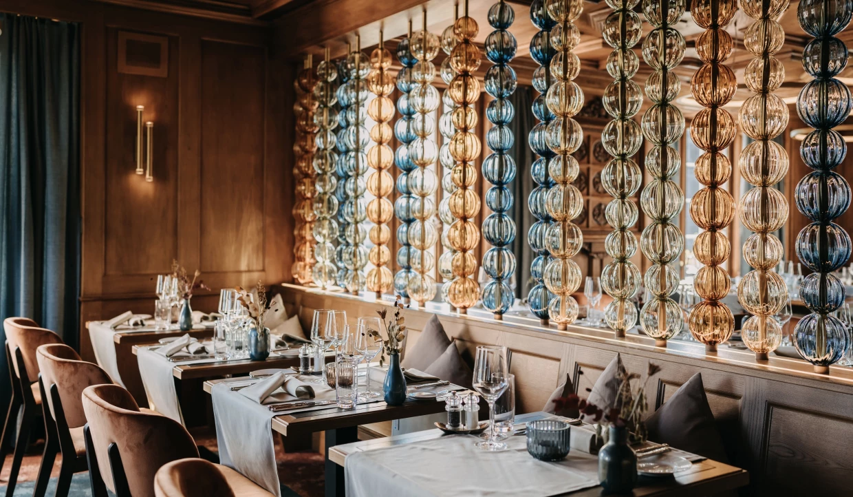 Restaurant tables with glass chains as decoration in background
