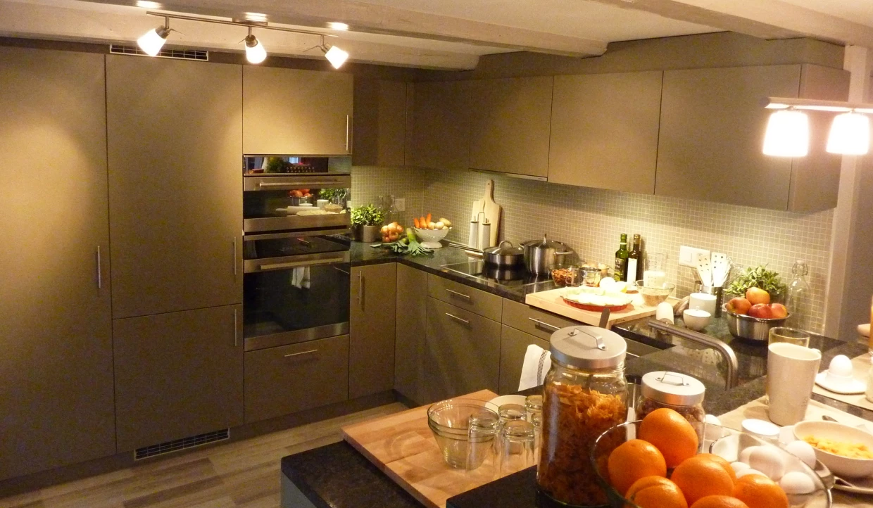 Moderne Küche mit grauen Schränken und Obst auf der Theke