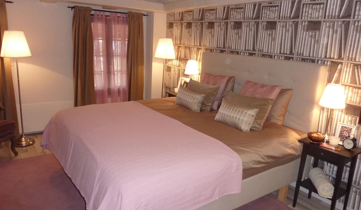 Schlafzimmer mit Doppelbett und Bücherregal-Tapete