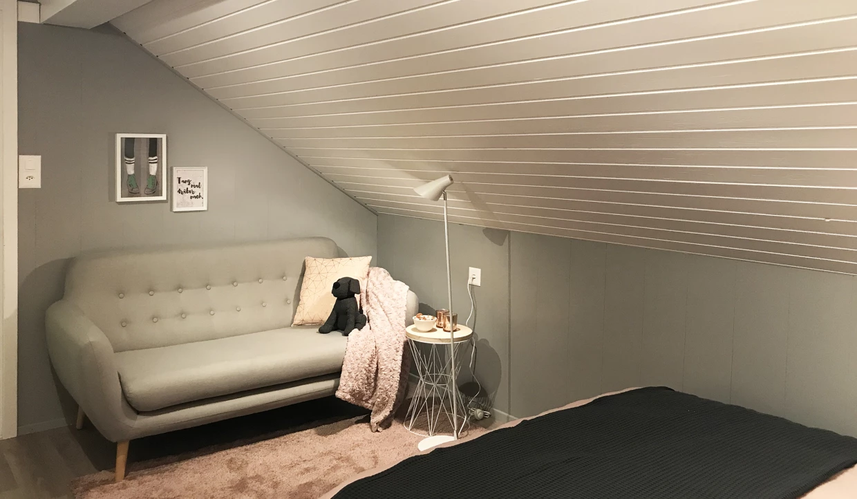 Wohnbereich mit grauem Sofa und Stehlampe