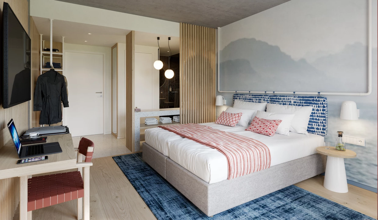 Hotel room with double bed, desk, and bathroom in background