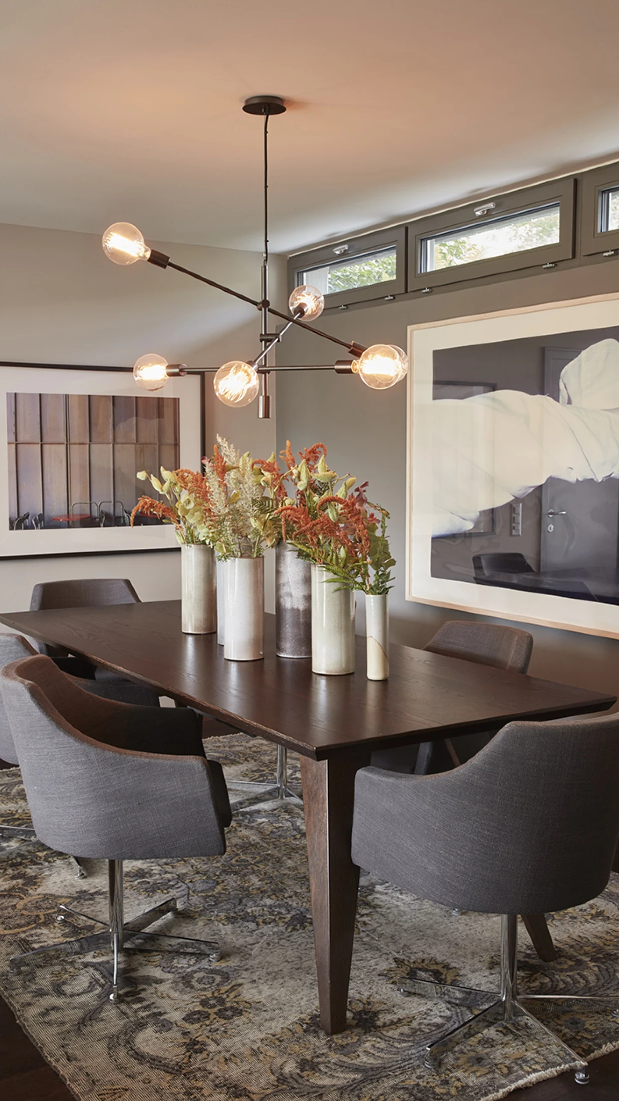 Esszimmer mit Blumen in hohen Vasen auf dem Tisch, moderne Beleuchtung