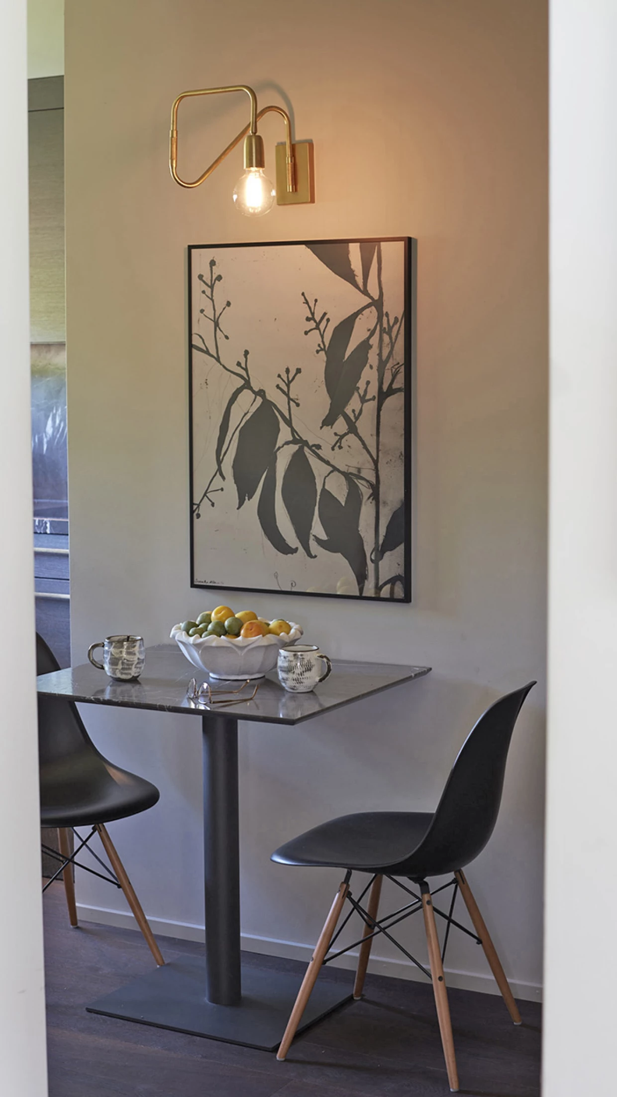 Kleiner Essbereich mit runder Tischplatte, zwei Stühlen und Wandkunst