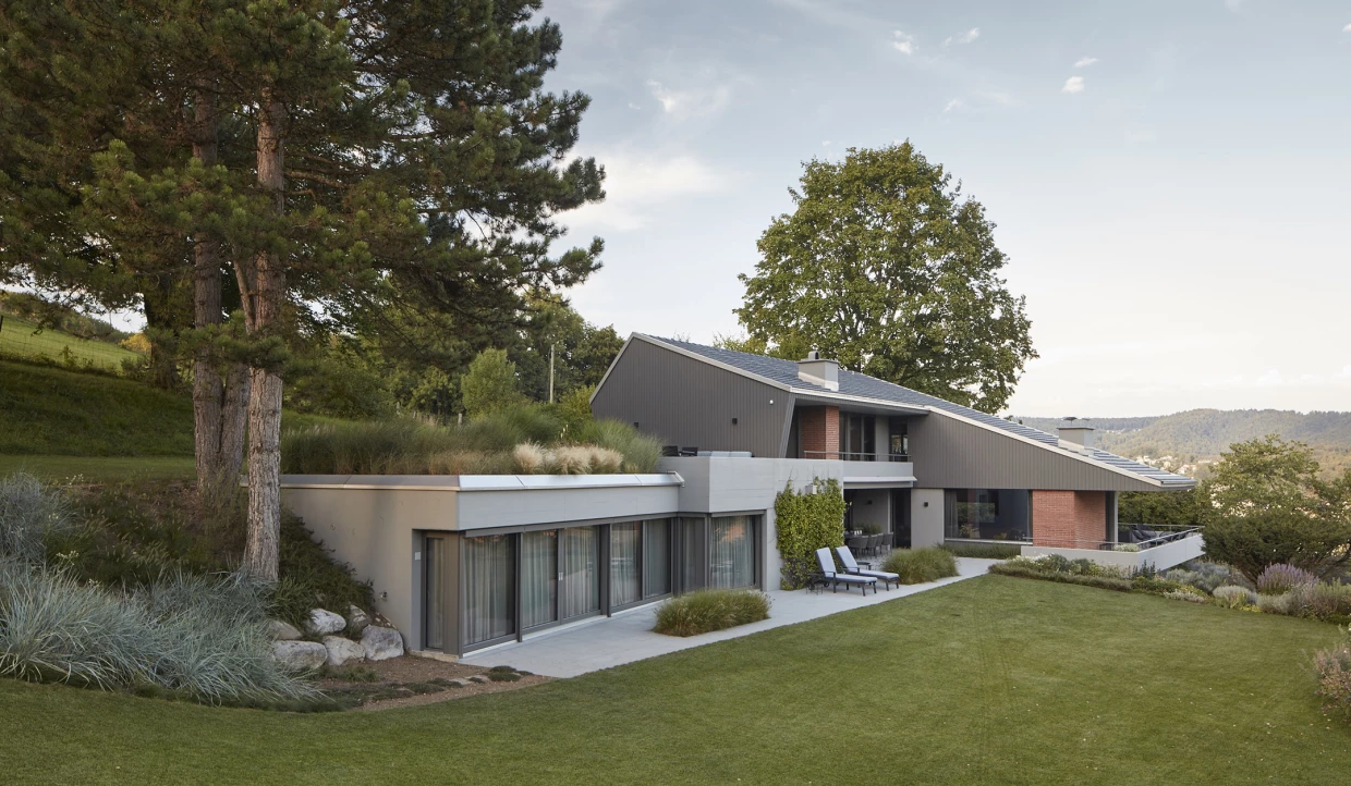 Modernes Haus mit begrüntem Dach und großen Fenstern in natürlicher Umgebung