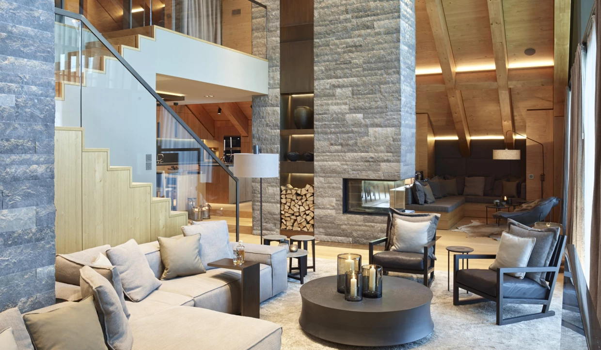 Living area with fireplace, wood paneling and stairs