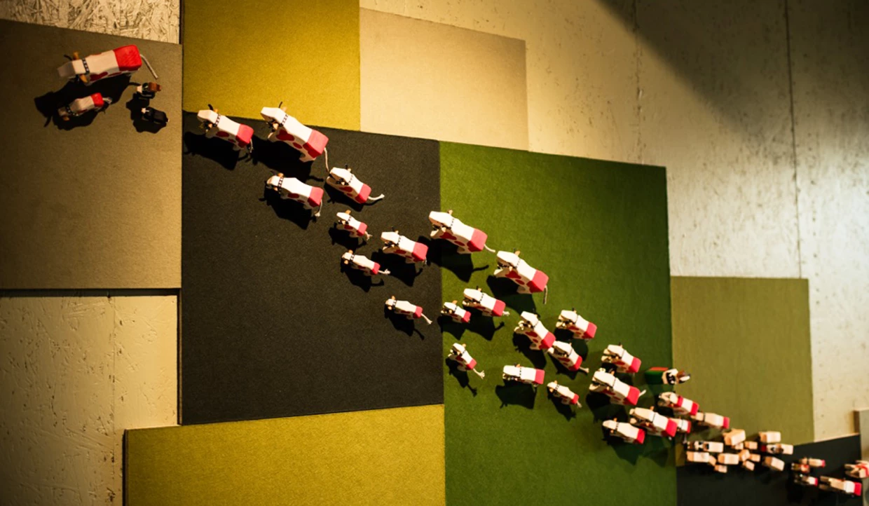 Wanddekoration mit kleinen, roten und weißen Kuhfiguren